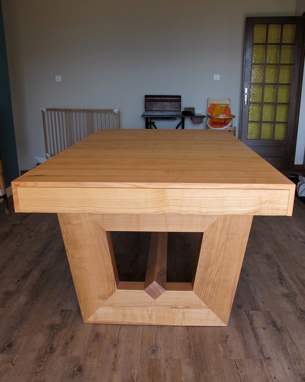 Cette table a deux pieds massif en forme de trapèze reliés au centre par une traverse basse. Les pieds ont une section de 20x7cm.