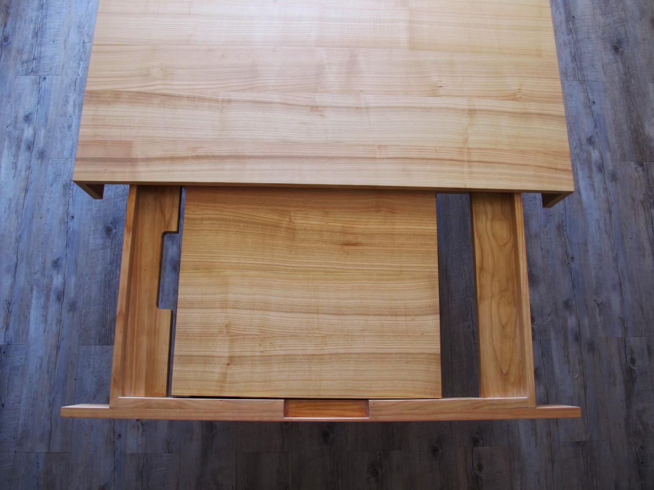 La longueur du plateau de la table peut être rallongée de 50cm par l'intermédiaire des rallonges rangées dans des tiroirs en bout de table.