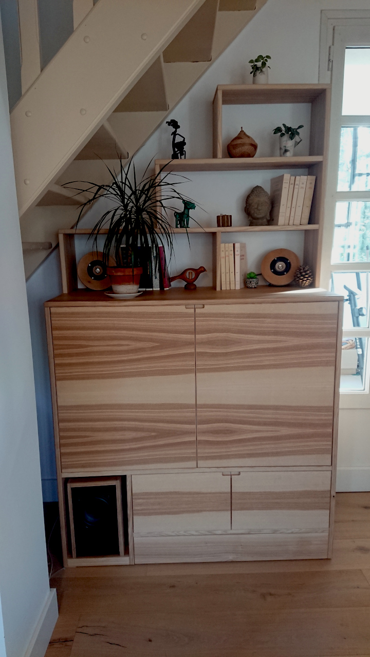 Le meuble TV possède 2 placard et un partie ouverte au dessus.