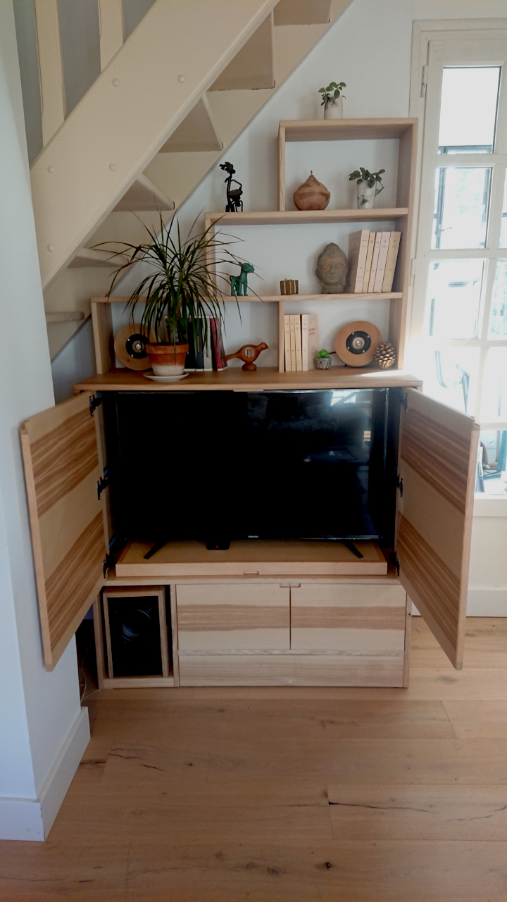Le placard du haut permet de cacher la télévision quand elle n'est pas utilisée.